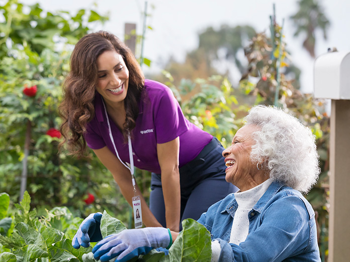 Older woman and younger woman laughing in garden