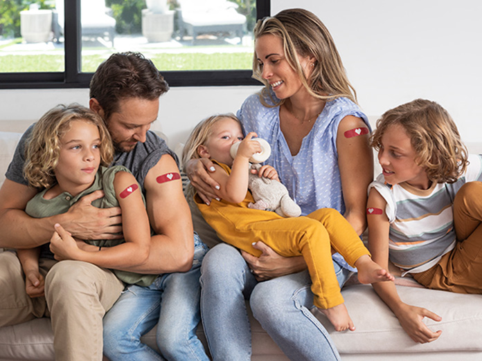 Family sitting displaying flu shots