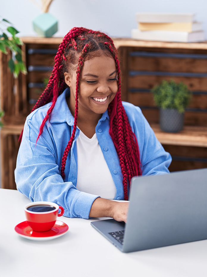 Lady in blue sitting on the laptop smiling