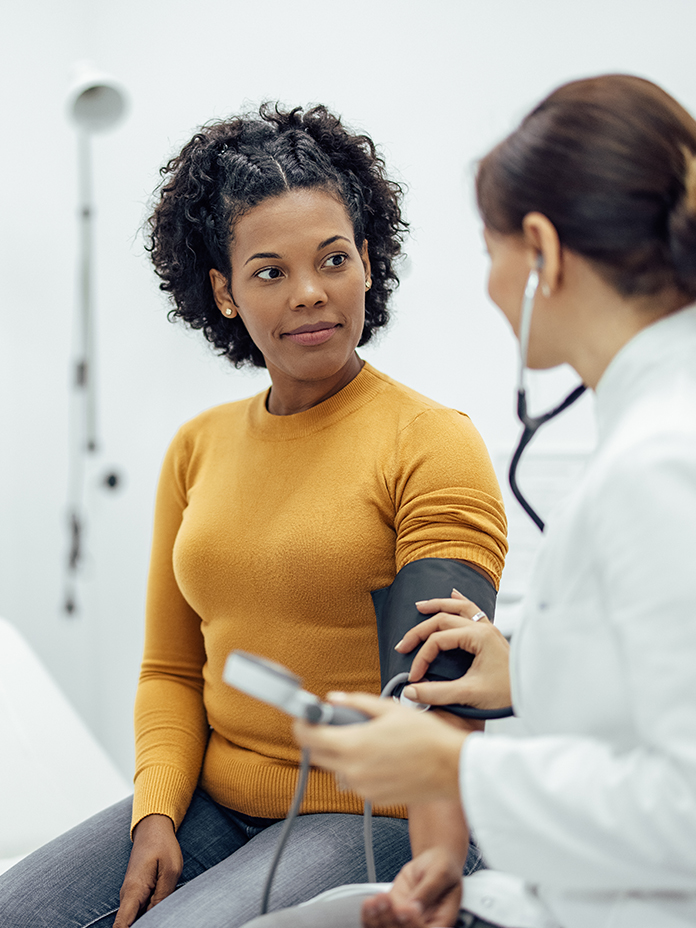 Woman in orange looking at doctor
