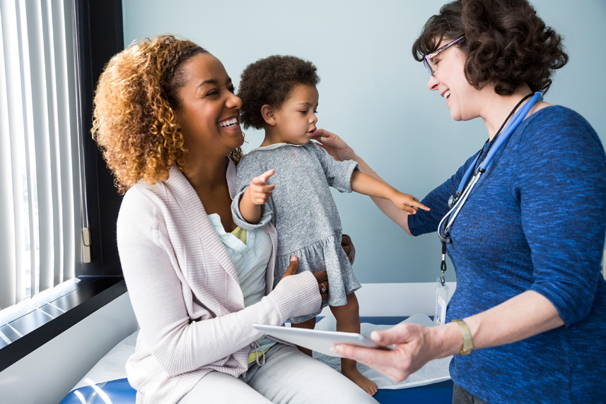 A woman and child smiling at a doctor.