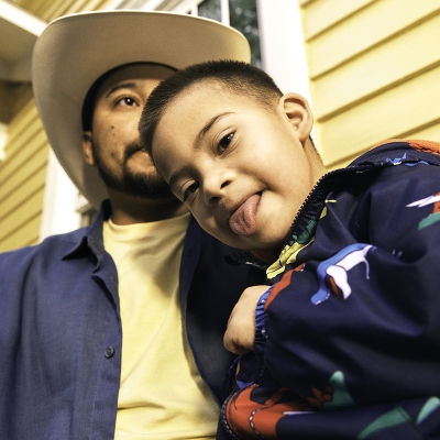A father and son in front of their house