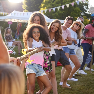 Adults and children playing tug-of-war