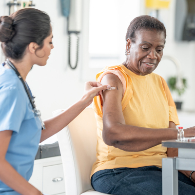 An elderly woman getting a flu shot at a clinic