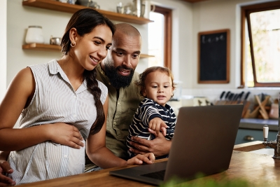 Parents with a child looking a laptop