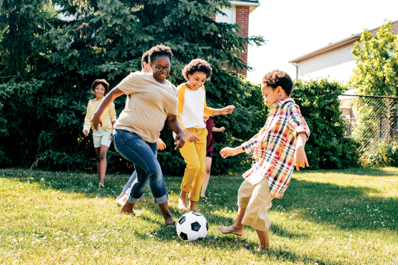 Kids playing soccer in a backyard