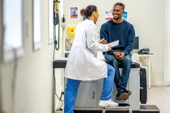 Un adulto joven hablando con un médico.
