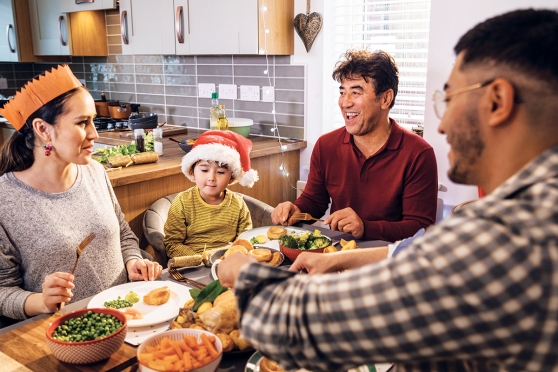 Una familia sentada alrededor de una mesa llena de comida.